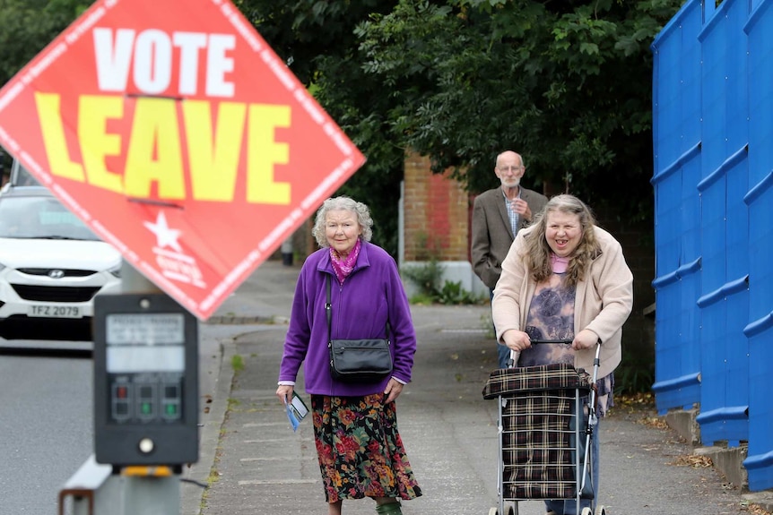 People walk past a Vote Leave sign