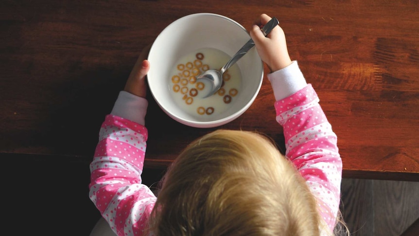 a young child eats a bowl of cereal