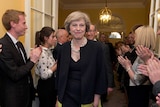 Theresa May is applauded as she walks into 10 Downing Street.