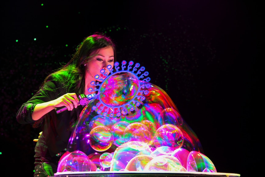 Melody Yang creates a mutiple-bubble creation on table.