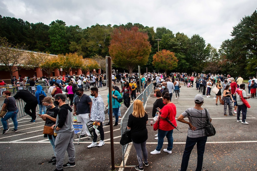 Hundreds of people wait in line for early voting on Monday, Oct. 12, 2020, in Marietta, Georgia