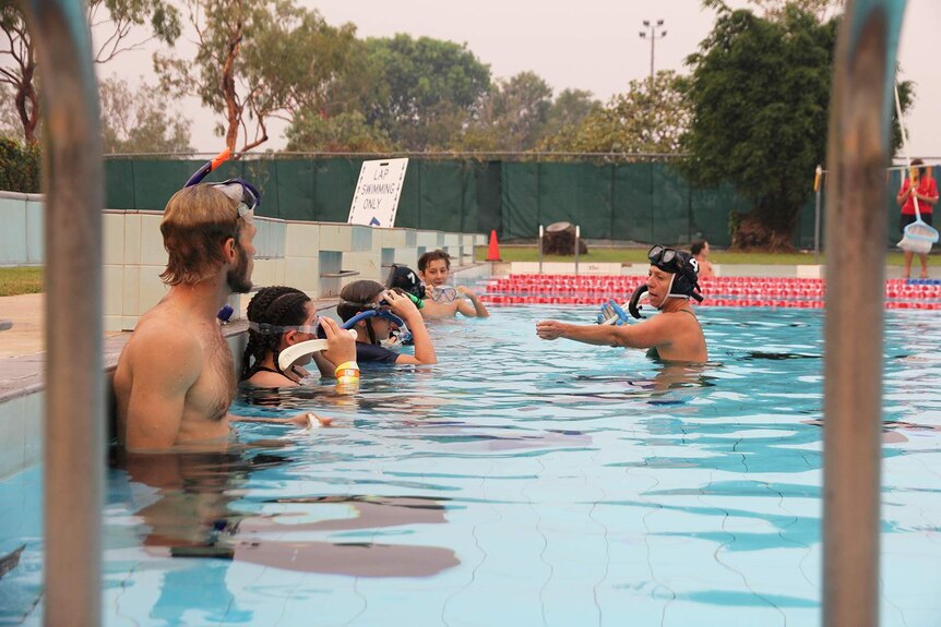A photo of the underwater hockey team lined against the end of the pool.