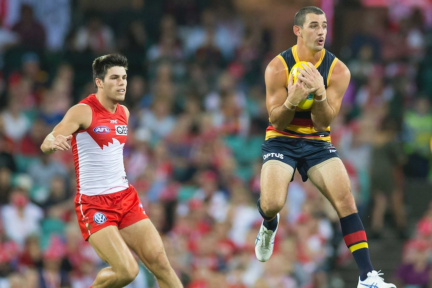 Taylor Walker takes a chest mark while in the air for the Crows against the Swans.