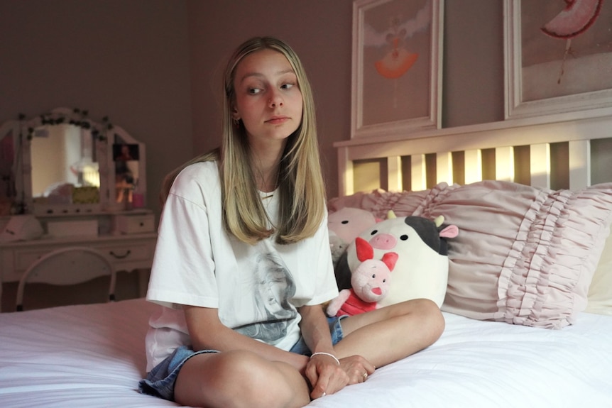 A Perth teenage girl sits on her bed