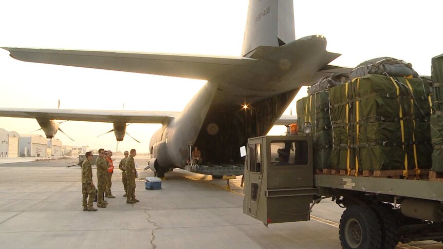 Australian Army personnel load humanitarian aid bundles at Al Minhad Air Base
