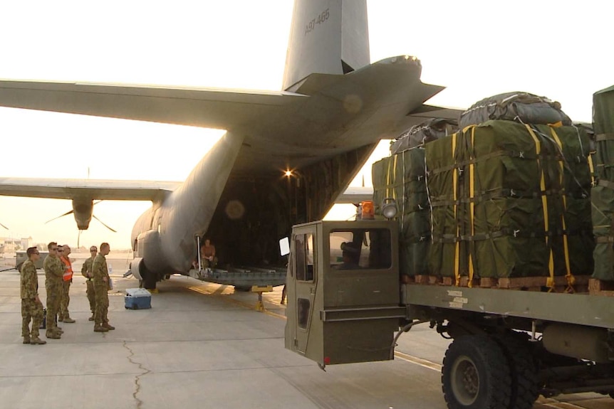 Australian Army personnel load humanitarian aid bundles at Al Minhad Air Base