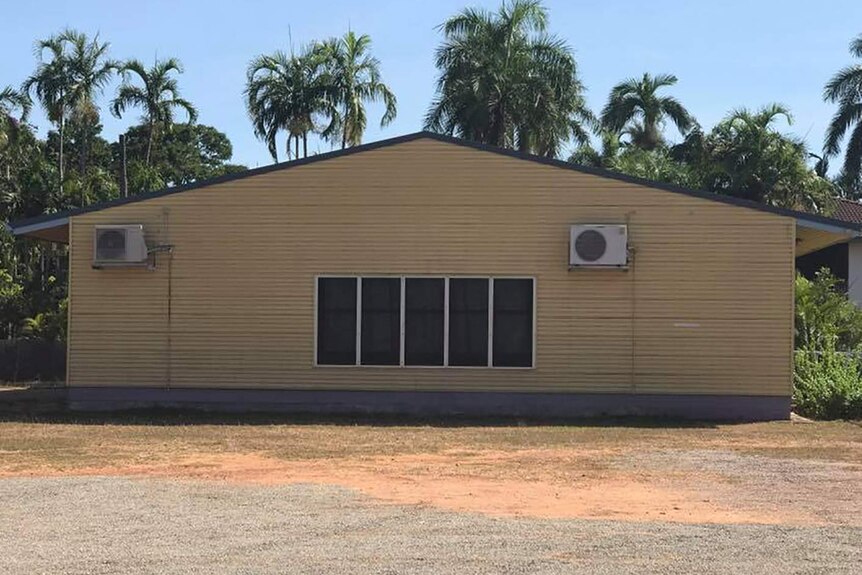 A photo of a house with two air-conditioners that resembles a face.
