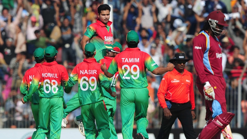 Chris Gayle (R) trudges off as Bangladesh celebrates on its way to a big win.