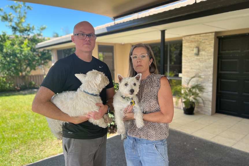 Jess and Jackie Morecroft stand in the driveway of their home.