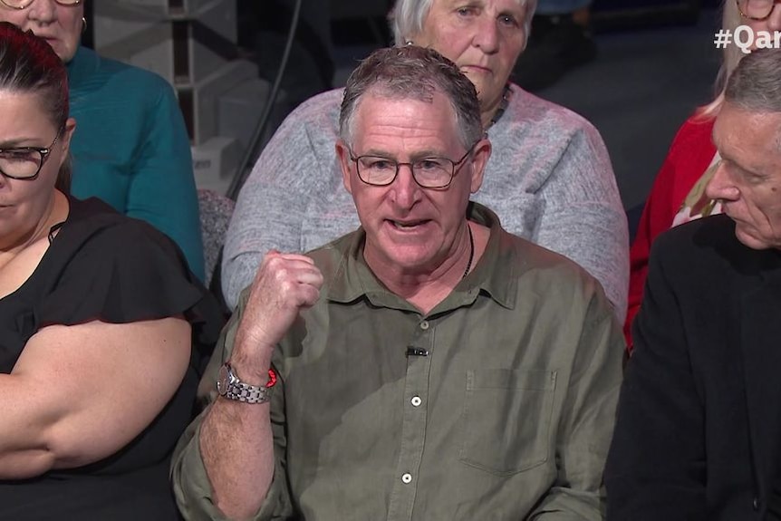 A man with glasses in a studio audience speaks.