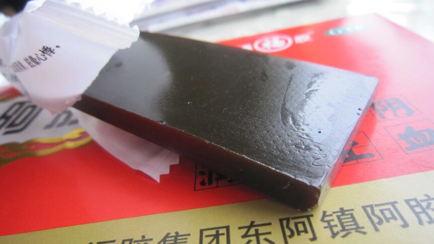 An opened piece of ejiao - glutinous brown square cake