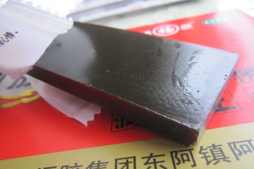 An opened piece of ejiao - glutinous brown square cake