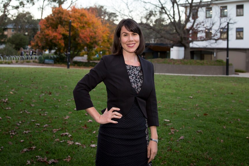 Associate Professor Kate Ogg standing outside university buildings