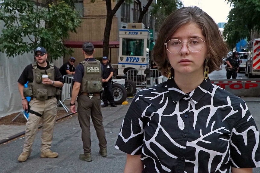 Jean Hinchcliffe stands in a New York street. Behind her are soldiers.