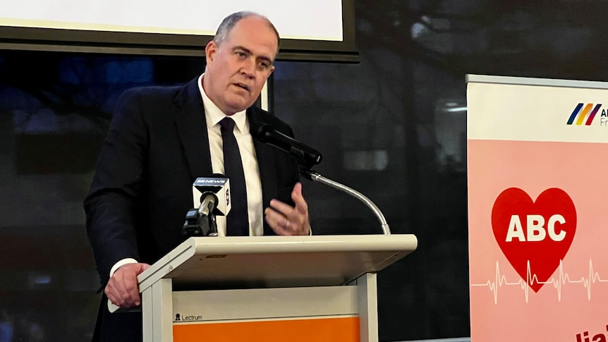 man in suit talking at lectern