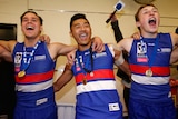 Three AFL players in red, white and blue raucously sing, with arms around each other