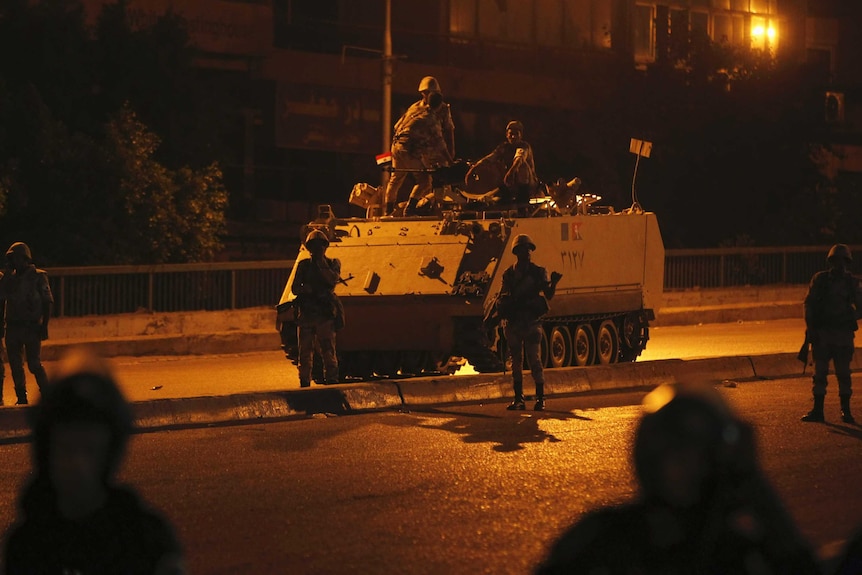 Army soldiers take their positions on the bridge towards members of the Muslim Brotherhood