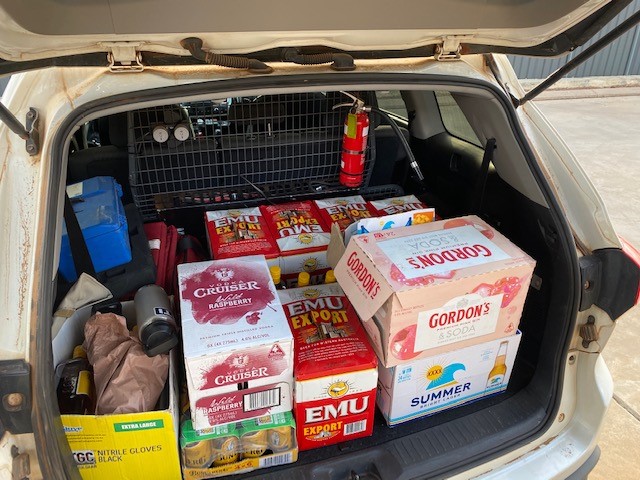 Cartons of liquor stashed in the boot of a white car