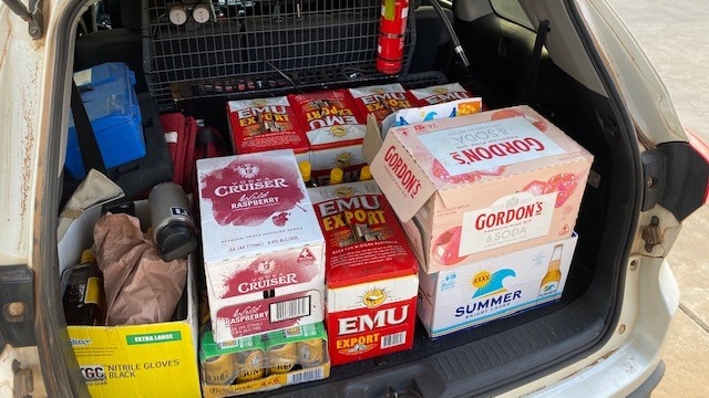 Cartons of liquor stashed in the boot of a white car