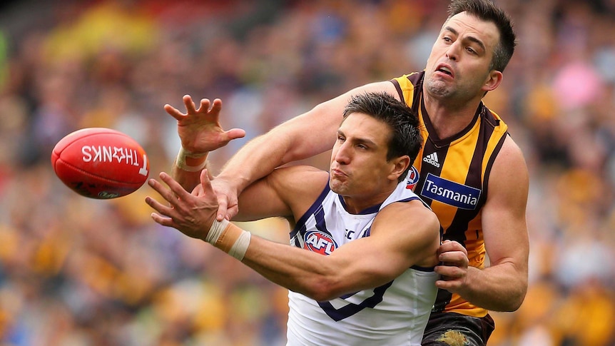 Fremantle's Matthew Pavlich and Hawthorn's Brian Lake contest for a mark during the AFL grand final.