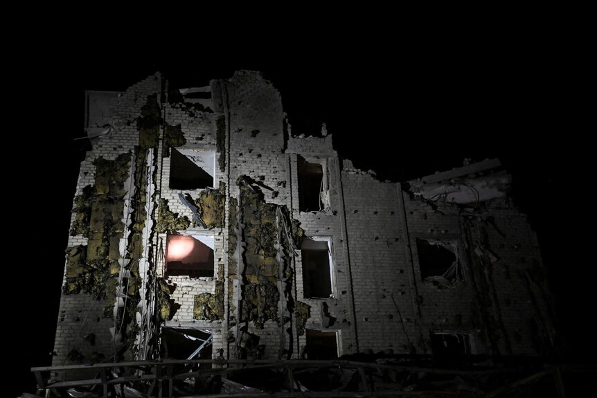 Night-time image of building damaged by missile strikes. 