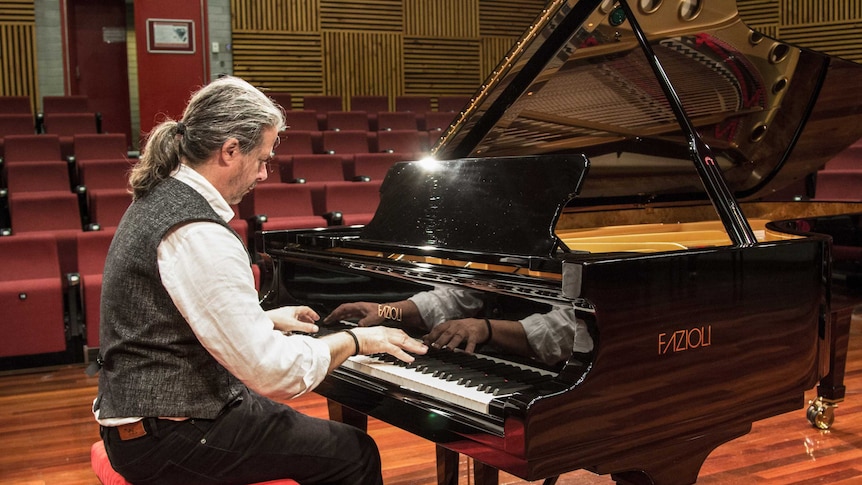 Paul Tunzi with the Fazioli piano he selected for the academy.