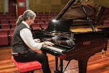 Paul Tunzi with the Fazioli piano he selected for the academy.