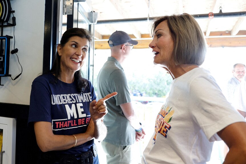 Nikki Haley speaks with Iowa Governor wearing a shirt that says 'underestimate me, that'll be funny'