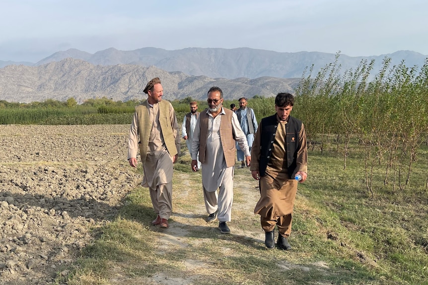 Men walking through farm in dry mountain country in Afghanistan