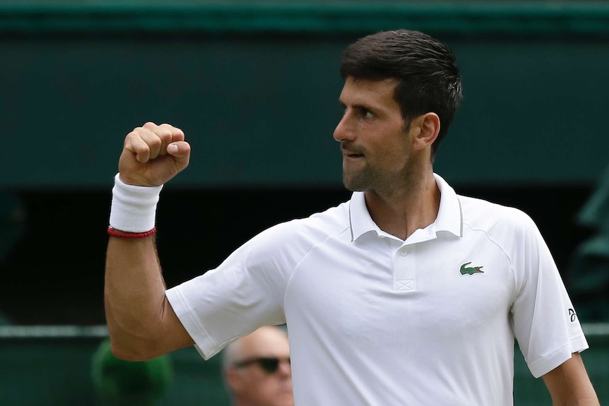 Novak Djokovic pumps his fist and looks to the side.