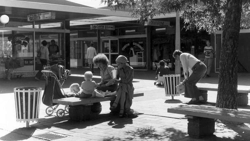 Families enjoy the sunshine at Curtin shops in 1970.