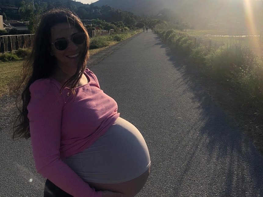 Natalie pictured heavily pregnant standing in front of a road in San Francisco.