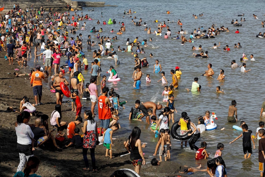 People frolic at the beach to celebrate Easter Sunday in Tanza, Philippines.