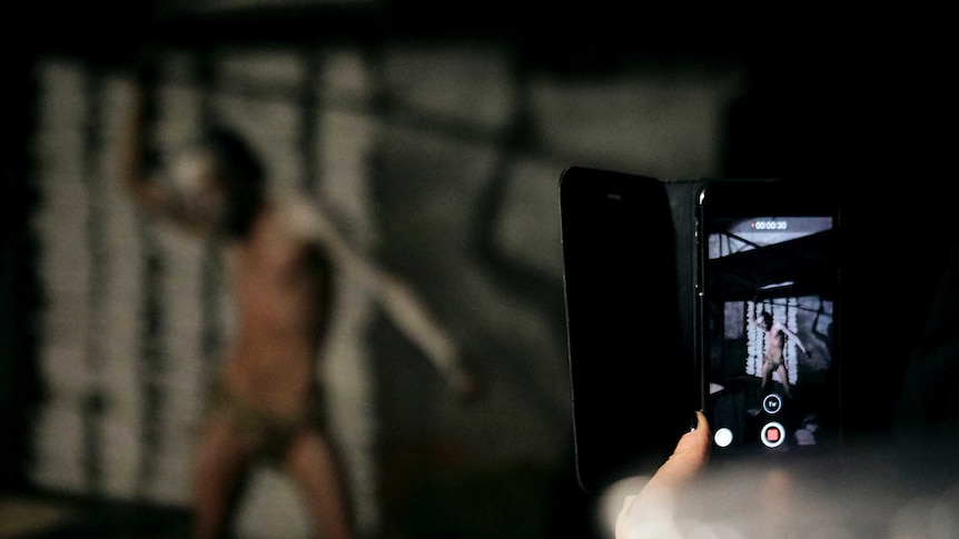 smartphone taking pick of semi naked man posing