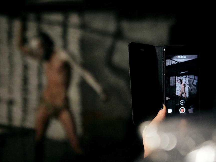 smartphone taking pick of semi naked man posing