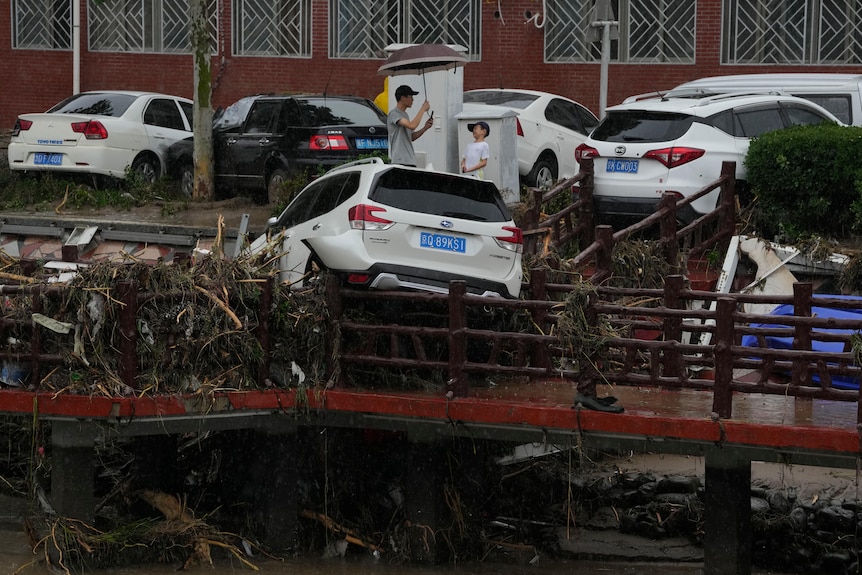 一辆被毁的汽车挂在桥边