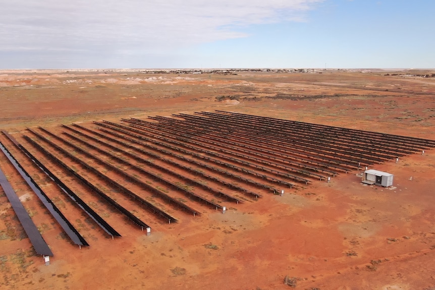 Rows of solar panels in a square shape surrounded by desert