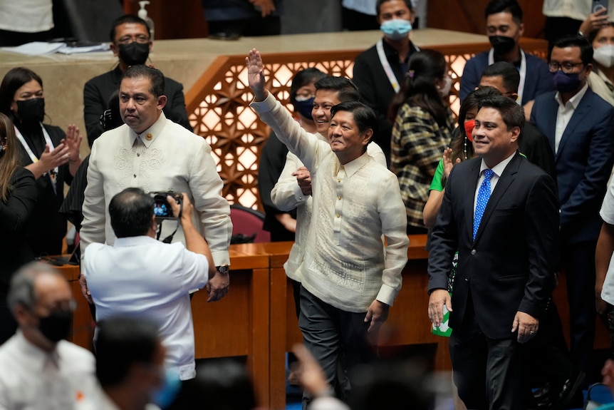 Man waves inside parliamentary building.