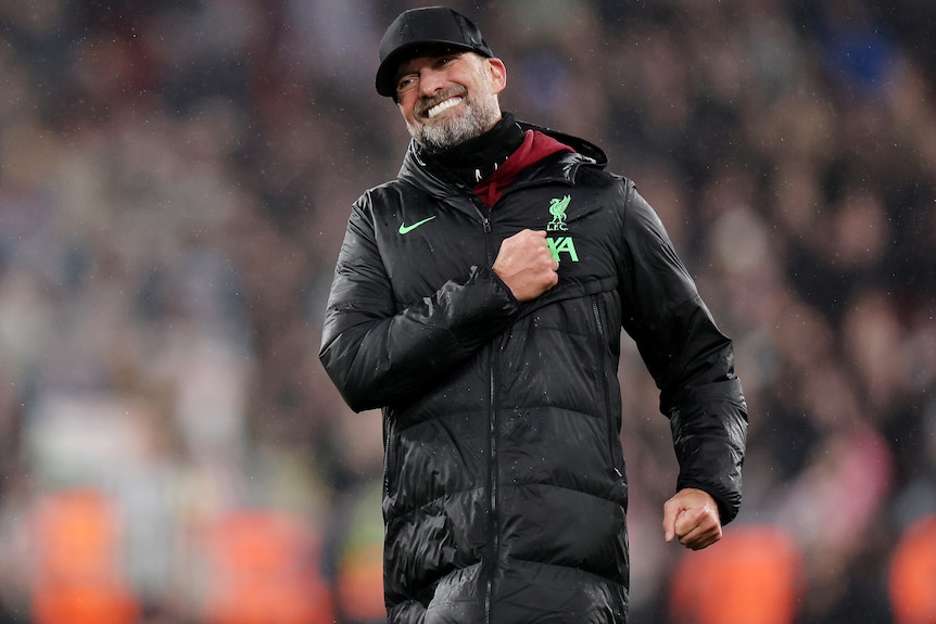 Jürgen Klopp thumps his chest with his left fist as he celebrates Liverpool defeating Newcastle United.