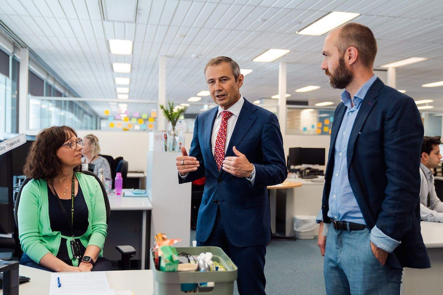 Two men and a woman in an office.