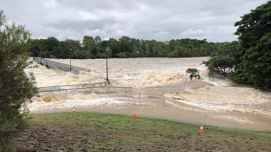 Floodwaters flow fast over Aplin's Weir in Mundingburra near Townsville on February 3, 2019.