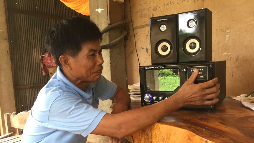 Cambodian man using a radio