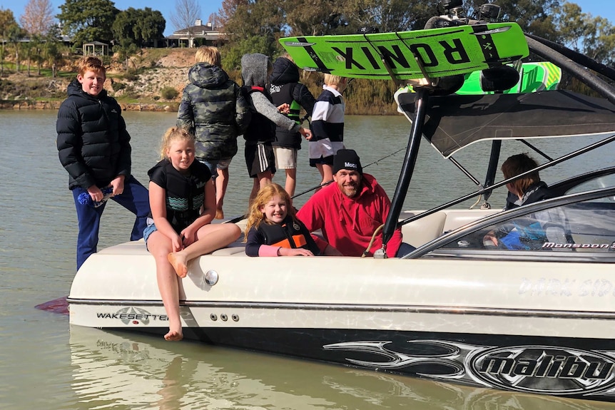 A group of adults and children on a boat in a river