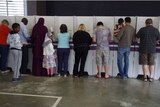 Voters at a booth mark their ballot papers.