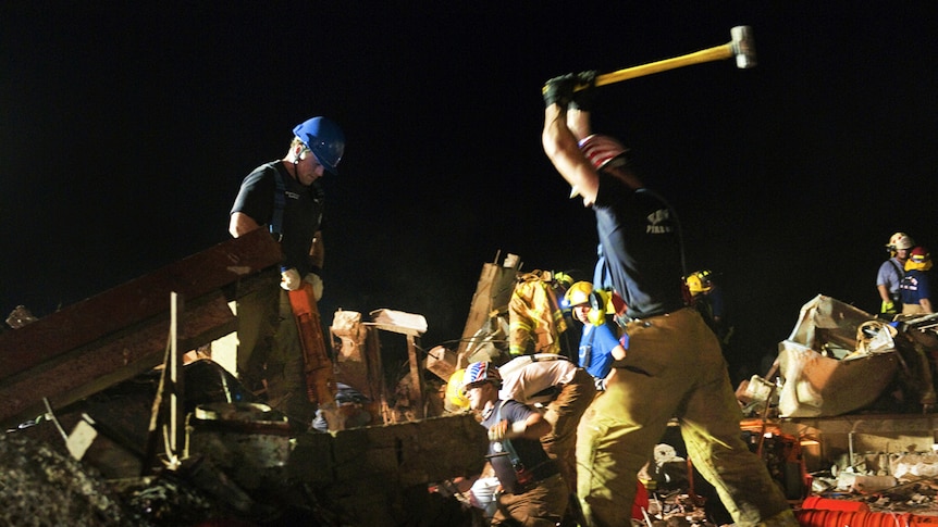 Firefighters break through concrete during the search for survivors in Moore