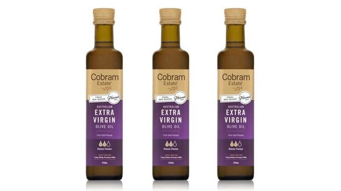 three olive oil bottles in a line with purple labels on white background