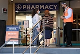 two people in masks trying to enter a pharmacy
