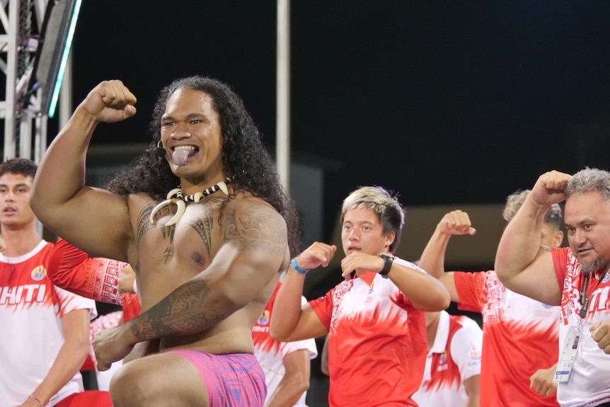 Tahitians perform a war dance at the closing ceremony.