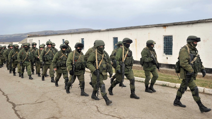 Armed men in military fatigues block access to a Ukrainian border guards base.