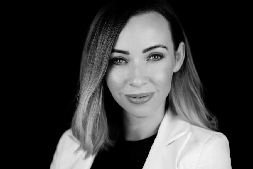 Monochrome photo of a woman with shoulder length hair wearing a white blazer